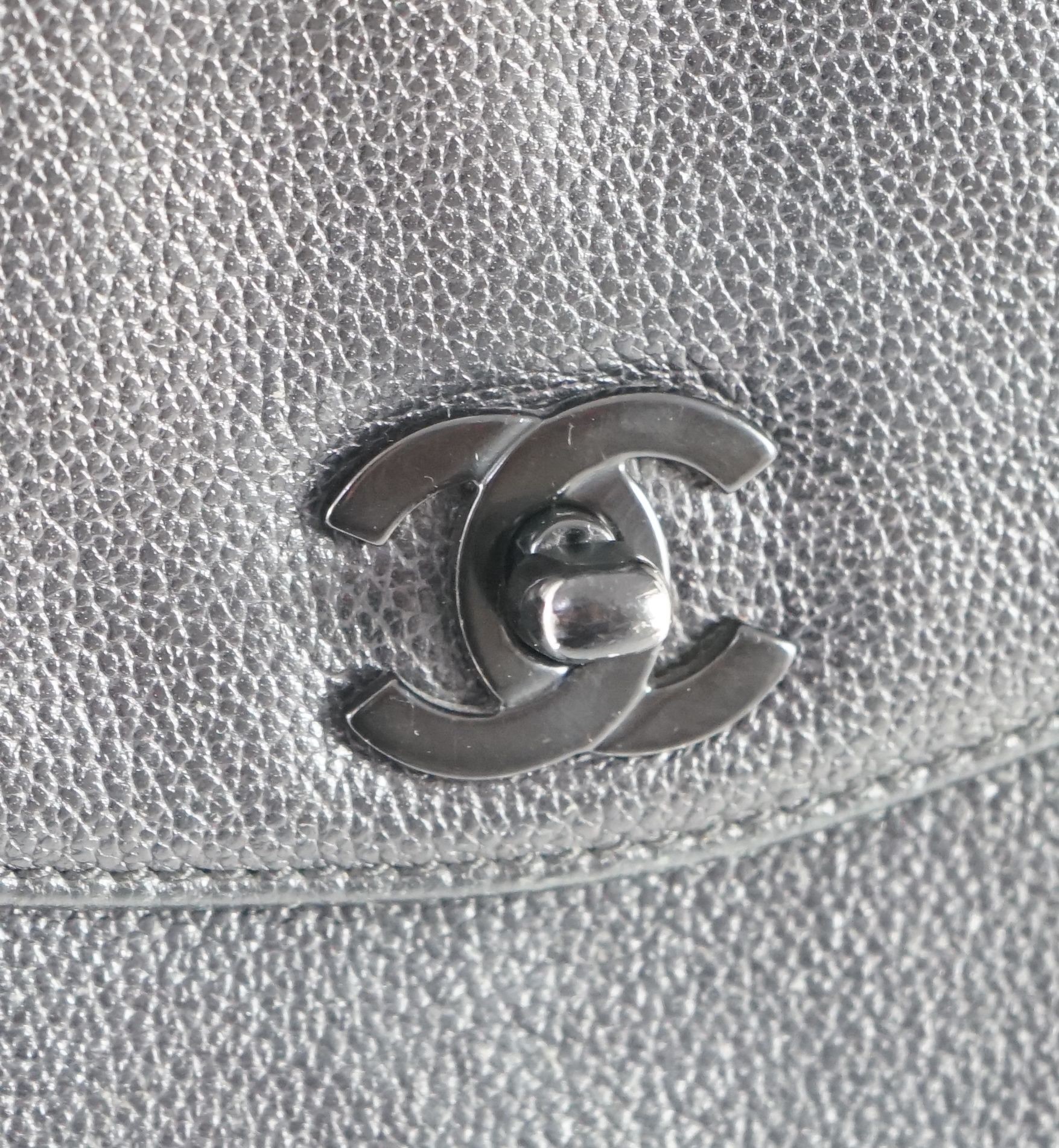 A black Chanel shoulder bag with two straps and Chanel logo lock